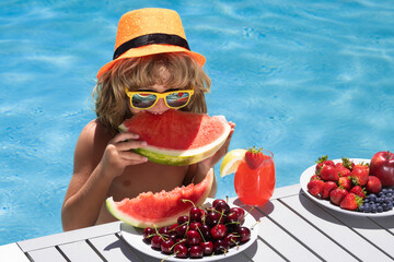 Summer fruit. Child eat watermelon. Kid with summer fruits in pool. Child in swimming pool playing...