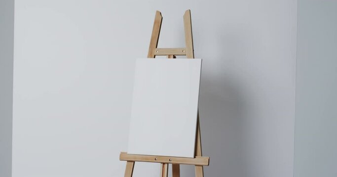 Video of white canvas sign on wooden easel with copy space on white background