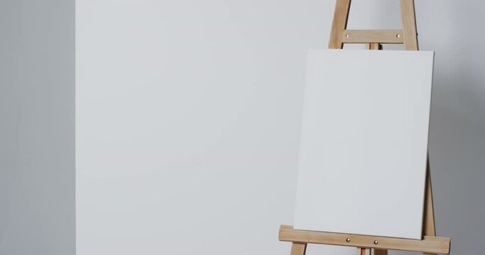 Video of white canvas sign on wooden easel with copy space on white background