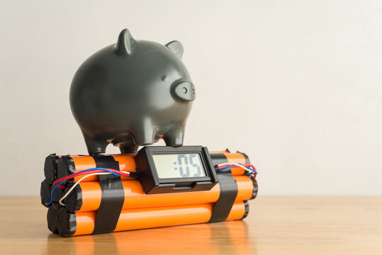Piggy bank on timb bomb wooden table with white wall background copy space. Concept of personal economy problem, inflation recession crisis, risk money savings, loss investment, burden installment.