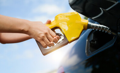Hand refilling the car with fuel at the gas station