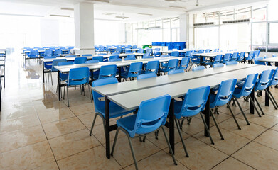 Clean school cafeteria with empty seats and tables