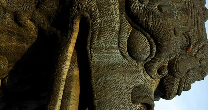 Vertical Close up dolly forward shot of the stone Garuda bird statue at the GWK (Garuda Wisnu Kencana) Cultural Park in Bali showing the texture a detail. Vertical shot for social media