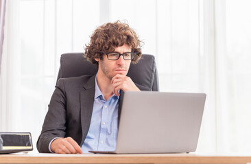 Portrait of stylish businessman works on laptop, Business man working on laptop in modern office