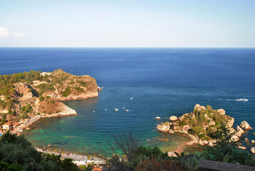Fototapeta na wymiar Photograph of the beautiful Isola Bella in the coast of Taormina in Sicily, houses, boats and trees.