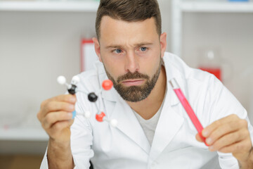 scientist holding molecule and test tube