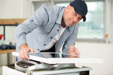 man installing induction hobs in a kitchen