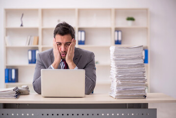 Young male employee unhappy with excessive work in the office