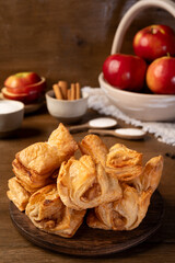 Puff pastry with apple on a wooden background. Mini pies. Delicious dessert. Breakfast.