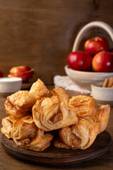 Puff pastry with apple on a wooden background. Mini pies. Delicious dessert. Breakfast.