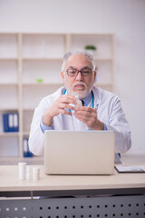 Old male doctor working in the clinic