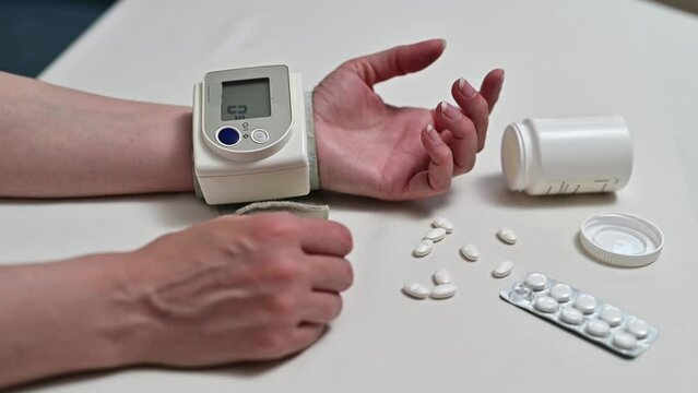 Woman checks blood pressure. Digital tonometry on a human hand. woman measuring blood pressure.
