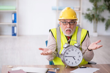 Old male architect in time management concept