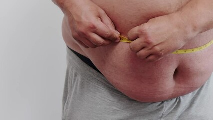 a fat man checks his fat with a measuring tape for obesity.