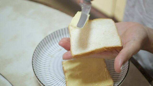 closeup video spread fresh butter on the toasted sliced bread for breakfast healthy meal.