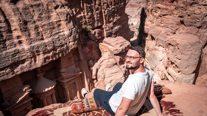 Tourist sitting atop high view point near the treasury petra jordan