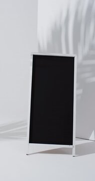 Vertical video of blackboard sign on white stand with copy space on white background