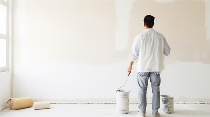 A person is currently painting the wall white