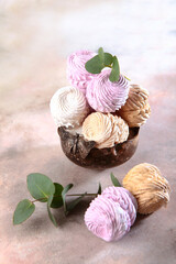 Multicolored marshmallows on a light background. Sweet dessert.Vertical photo.