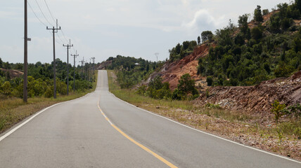 Beautiful open road or country road in Indonesia with green tree on the left and right. Pavement...