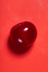 ripe cherry poured with juice close-up on a pink background, macro