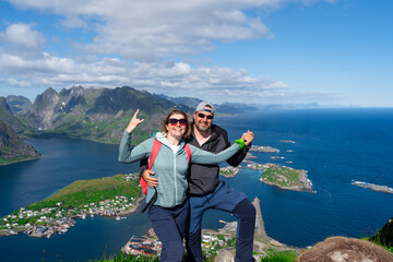 Happy Hiking couple enjoying Norway fjord view. Happy couple relax on top of Reinebringen, fjord....