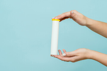 Tube for vitamins, pills in hand. Packaging. Mockup