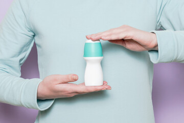 Body deodorant roll-on in woman's hand