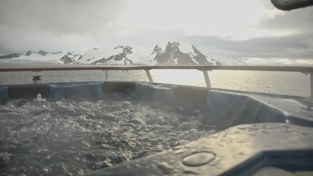 Hot tub with bubbles and steam and big snow and ice covered mountains in background