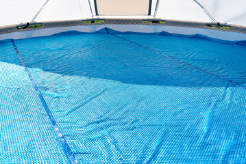 A large expansion pool with a diameter of 3.96 m, set in the yard next to the house, covered with a...