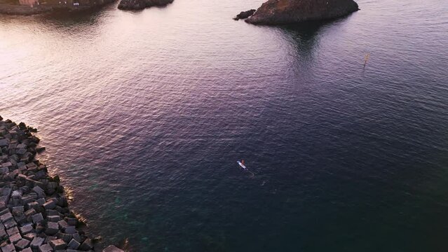 Aerial view of traditional boat and sup sailing on the mediterranean sea towards the stacks at Aci Trezza near Catania in Sicily, Italy, at dawn.
Islands of Greek mythology of Polyphemus.