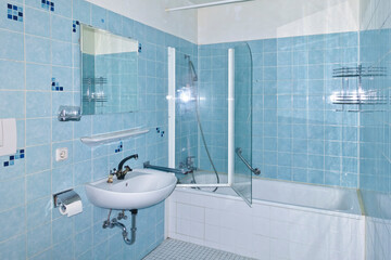 Unrenovated bathroom from the 1970s with the original blue tiles, seventies style. Outdated,...