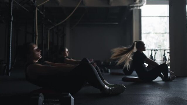 Women Athletes Doing Exercise Lying On Floor Of Modern Fitness Center, Healthy Lifestyle And Sport