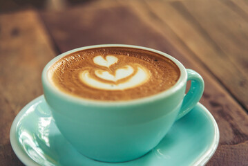 Latte art coffee cup with milk on wooden table. Espresso shot make latte art hot coffee cup. Cappuccino with milk in italian coffee shop cafe. Brown hot caffeine beverage in cafeteria with copy space