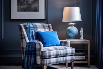 A contemporary living room design featuring various shades of grey, adorned with a vibrant touch of bright blue plaid and a book placed on a chair.