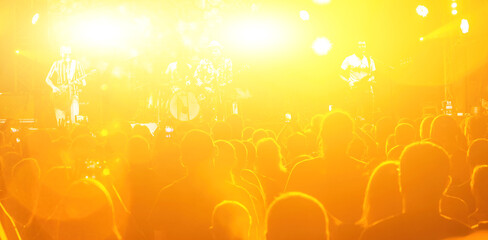 The stage lighting effect in the dark. Happy young people. Lifestyle concept. Crowd at concert and blurred stage lights