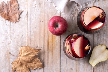 Autumn sangria with pear and apple on wooden table. Top view. Copy space