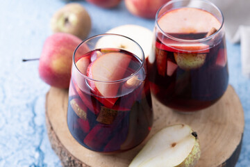 Autumn sangria with pear and apple on blue background