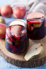 Autumn sangria with pear and apple on blue background