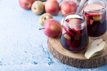 Autumn sangria with pear and apple on blue background. Copy space