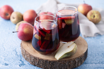 Autumn sangria with pear and apple on blue background