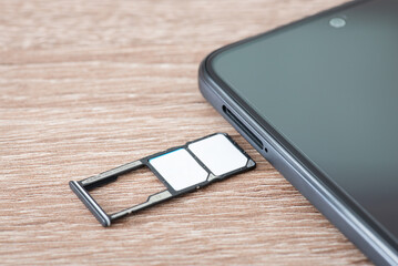 Two sim cards of different mobile operators in a phone tray. Close up of modern smartphone and...