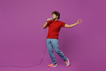 Full body young singer fun happy Indian man he wearing red t-shirt casual clothes sing song in...