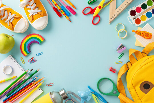 Unlock the potential of educational process with this top-view photograph showcasing variety of school supplies on an isolated blue backdrop. Utilize the copy-space for text or promotional messages