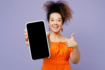 Young surprised latin woman wear orange blouse casual clothes hold in hand use mobile cell phone...