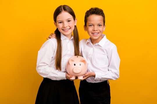 Photo of two pupils schoolkid boy girl hold piggy bank save money for academic courses tuition isolated shine color background