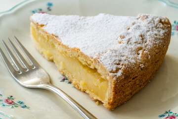 A piece of Custard cream cake with pine nuts. Traditional italian cake - torta della nonna or...