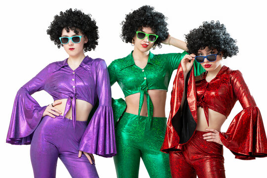 A group of disco girls in African American wigs and colorful costumes on a white background. Fashion of the seventies and eighties.