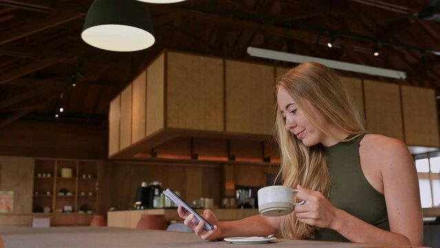 A young woman in a cafe with a cell phone