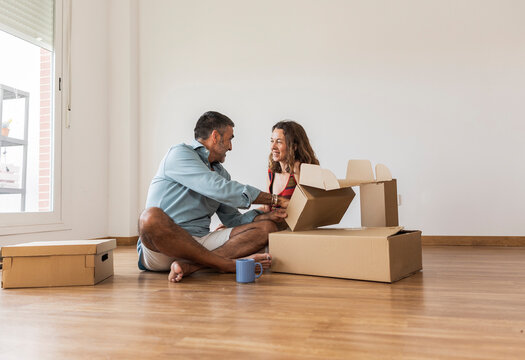 happy mature couple on the floor with moving boxes